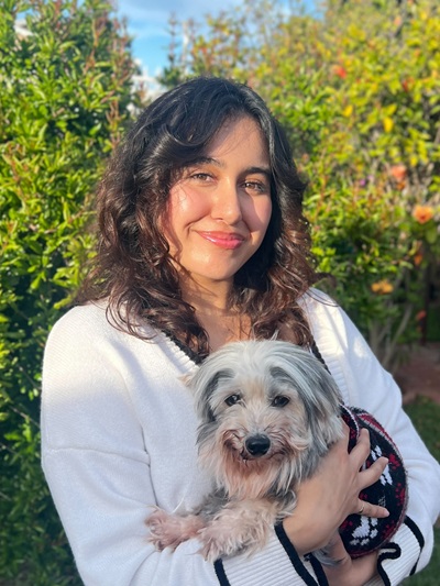 Yasmin Medina standing holding a white dog