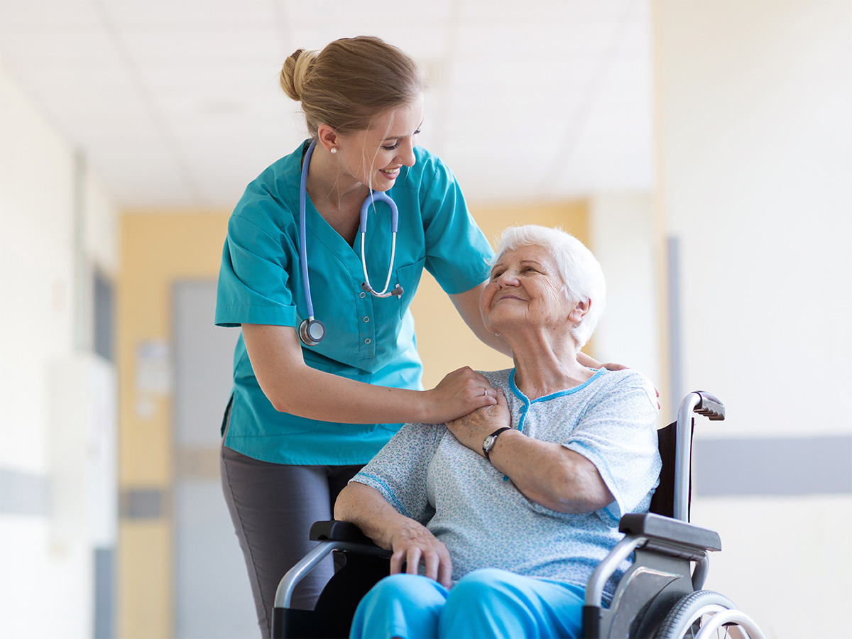 nurse comforting patient in wheelchair