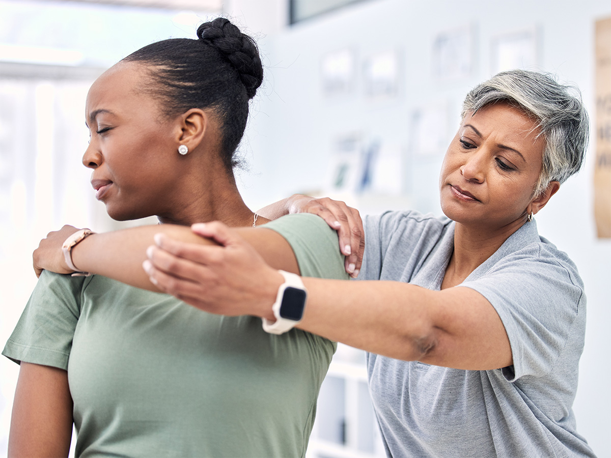 physical therapist helping patient with shoulder