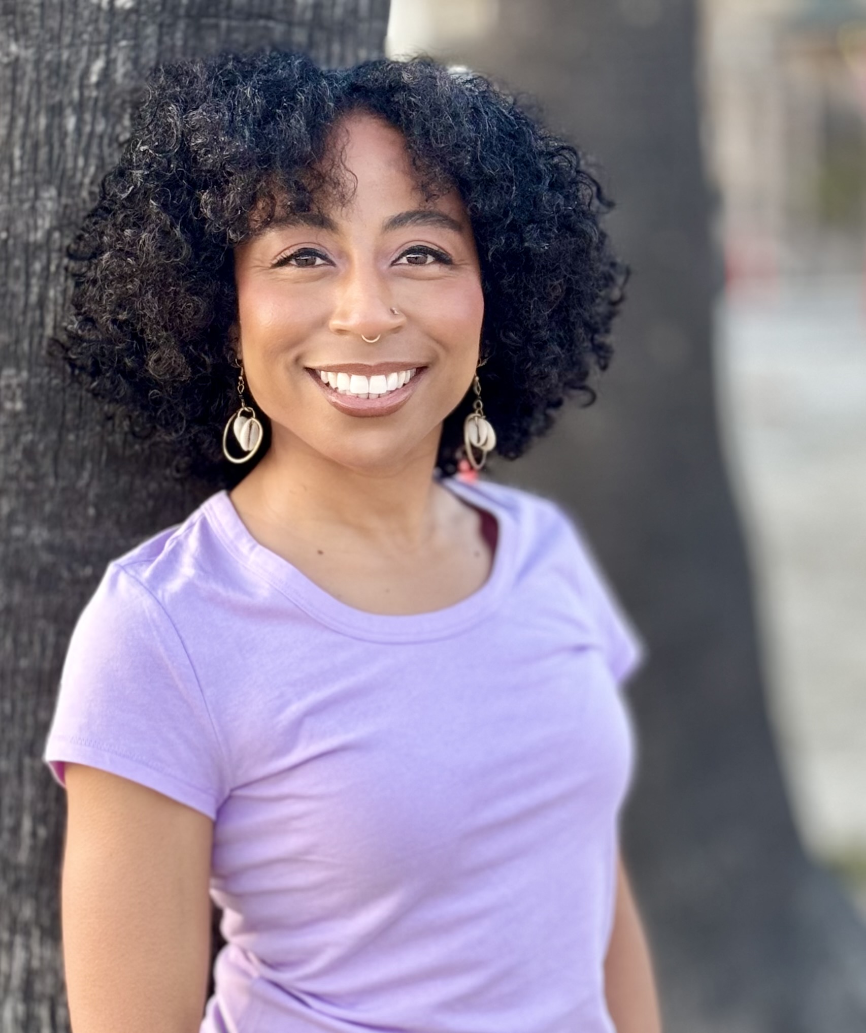 Black woman in a purple t-shirt smiling