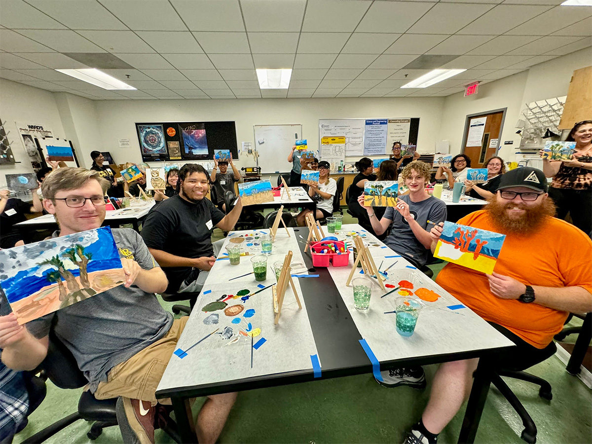 group presenting their paintings