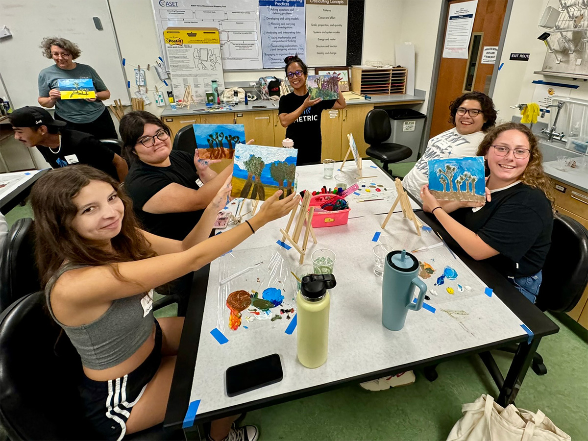 group presenting their paintings