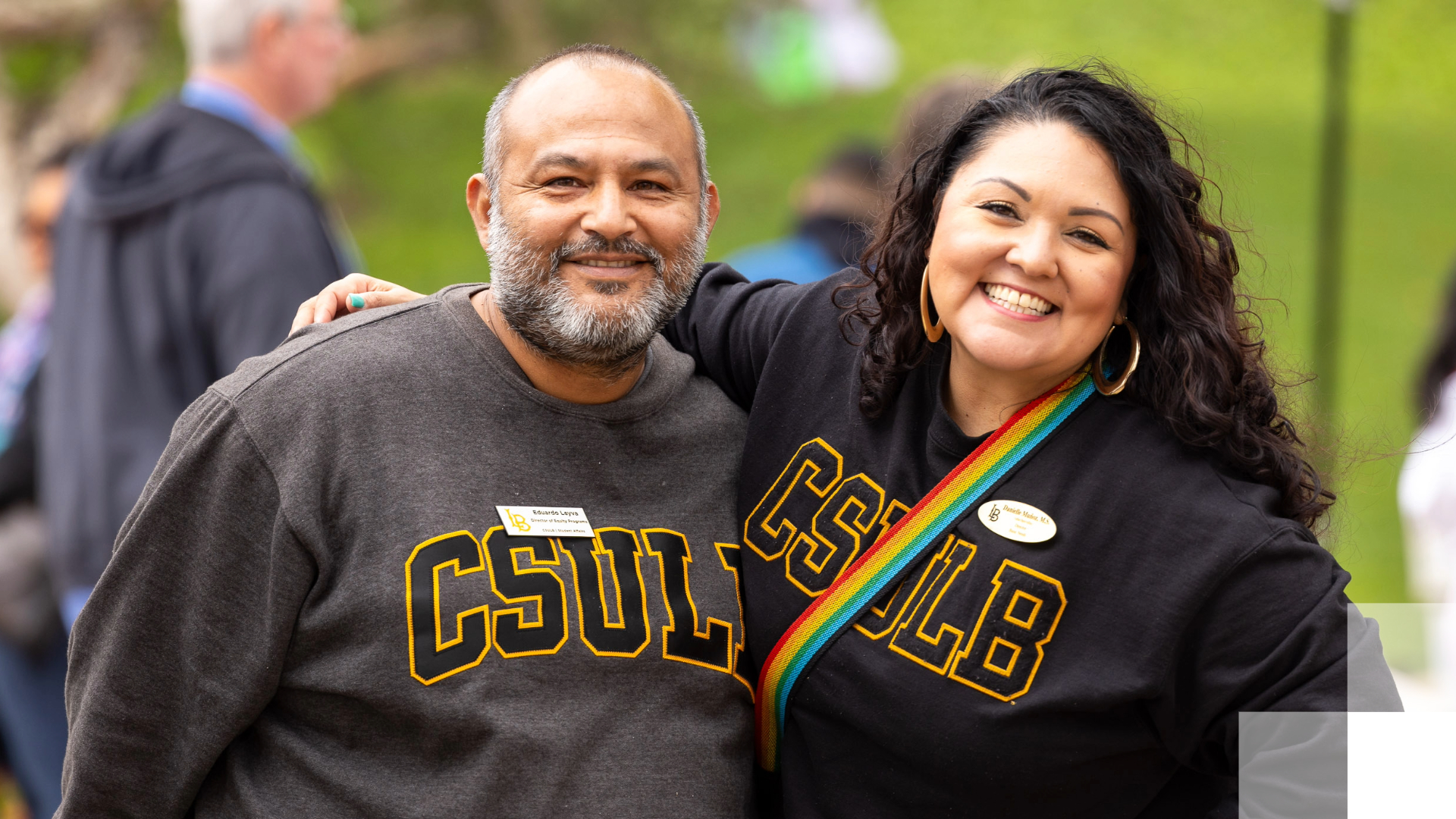 Two people in CSULB sweatshirts smile. 