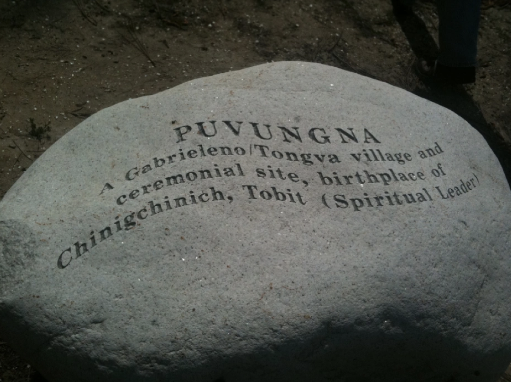 A stone is engraved with text marking Puvungna, a Gabrielino/Tongva village and ceremonial site.