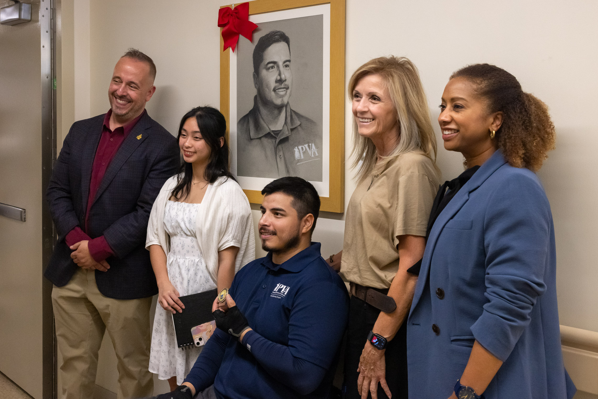 Jose Reynoso, center, with others in front of his portrait