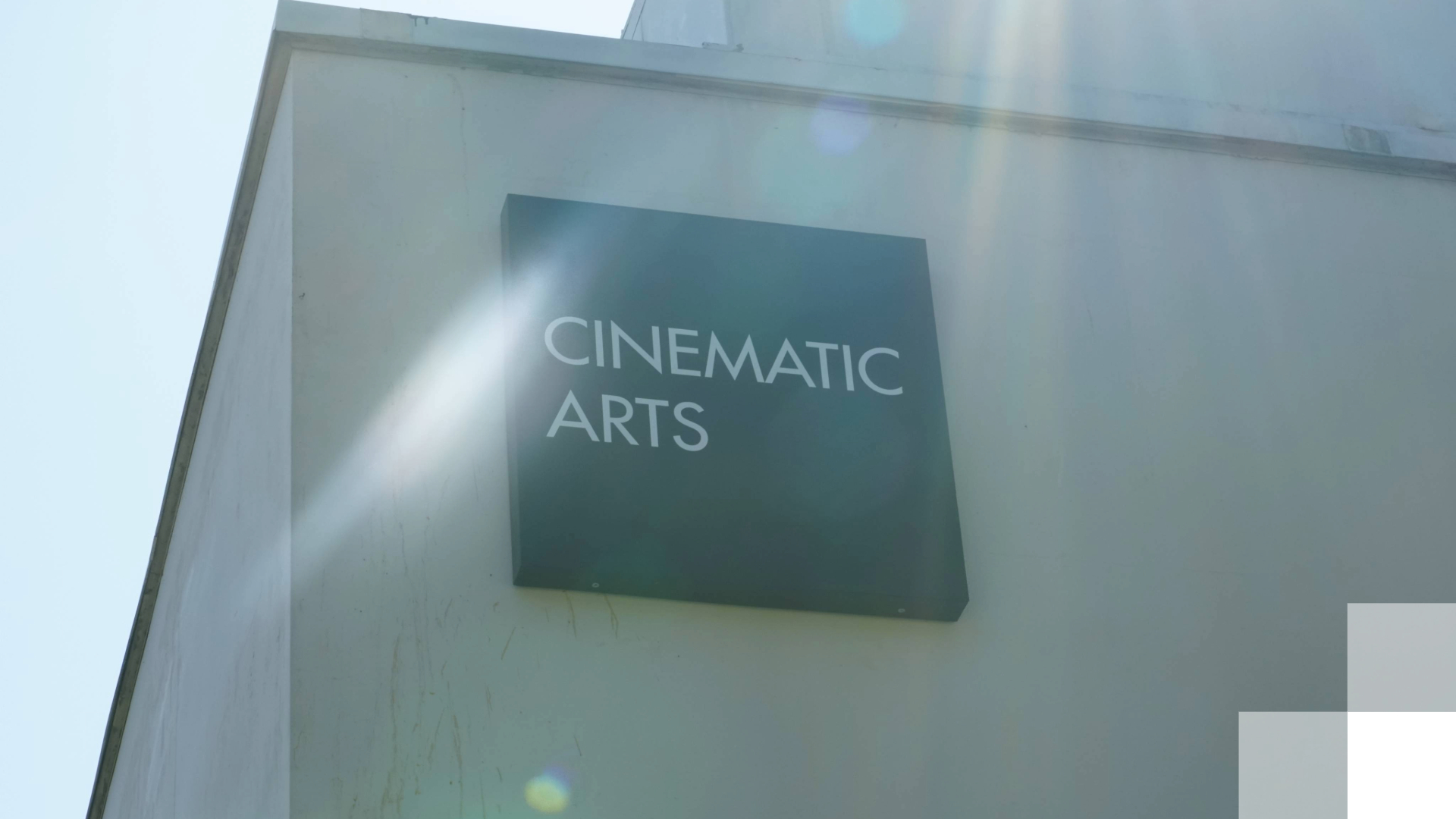 A sign of the side of a building reads "Cinematic Arts."