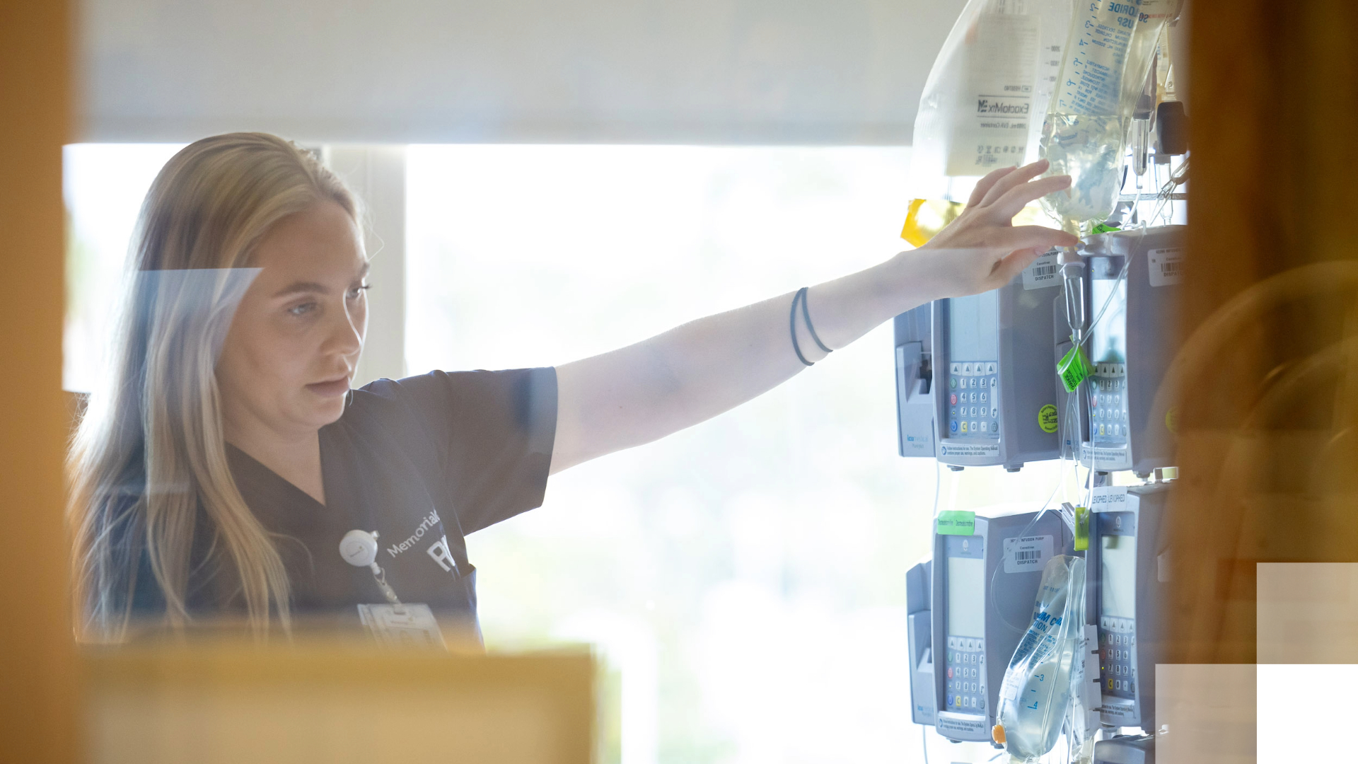 A nurse reaches for a machine.