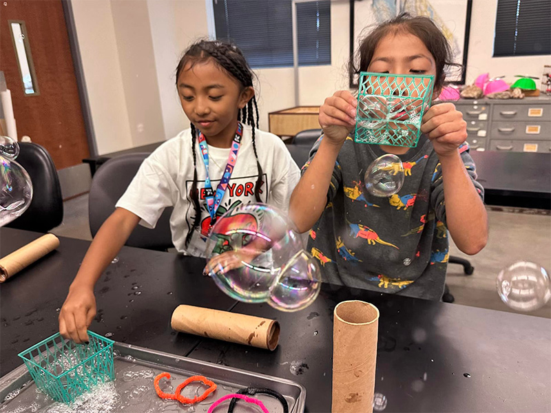 young children blowing bubbles