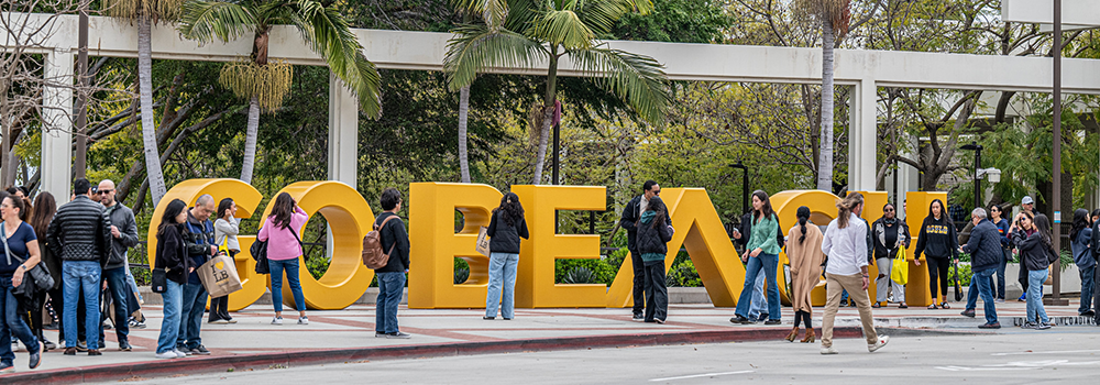 People walking by the Go Beach sign