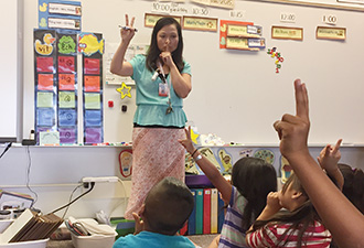 Ms. Dang teaches kindergartners classroom rules in Vietnames