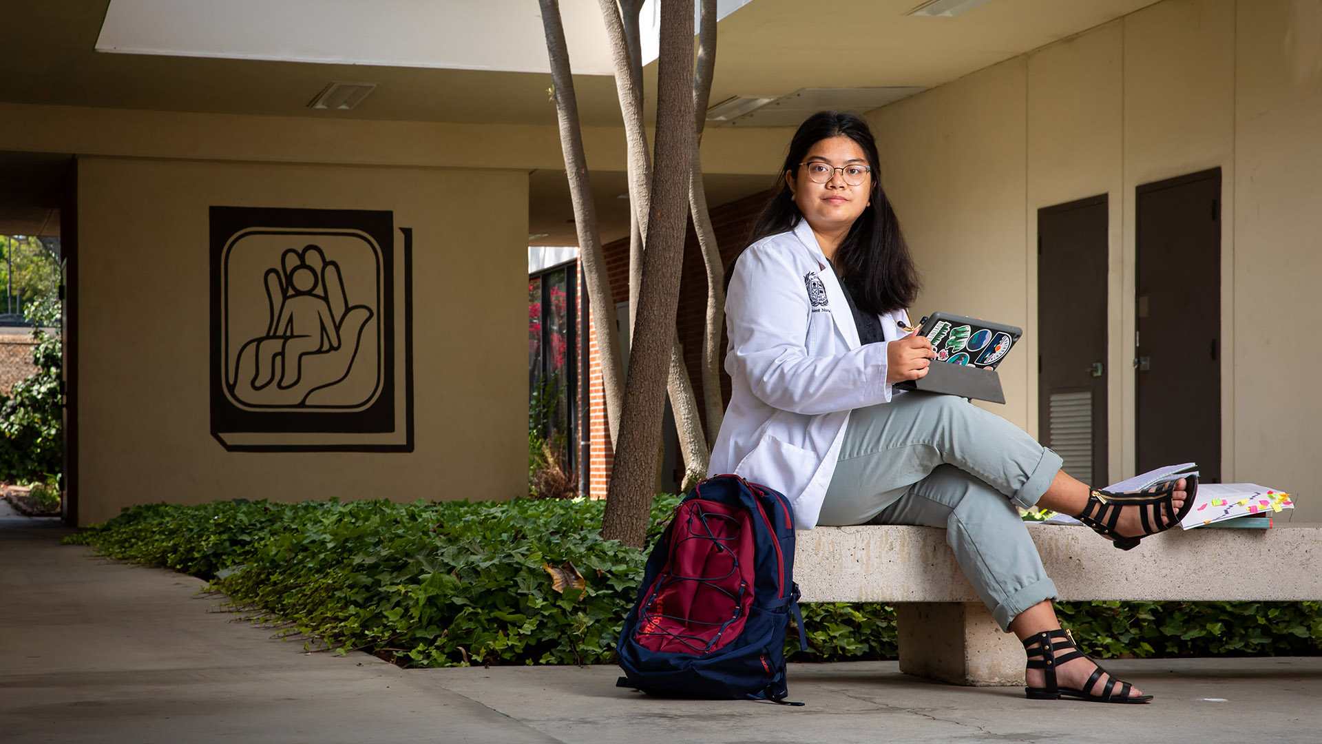 Nursing student Elaine Araneta sitting on concrete bench