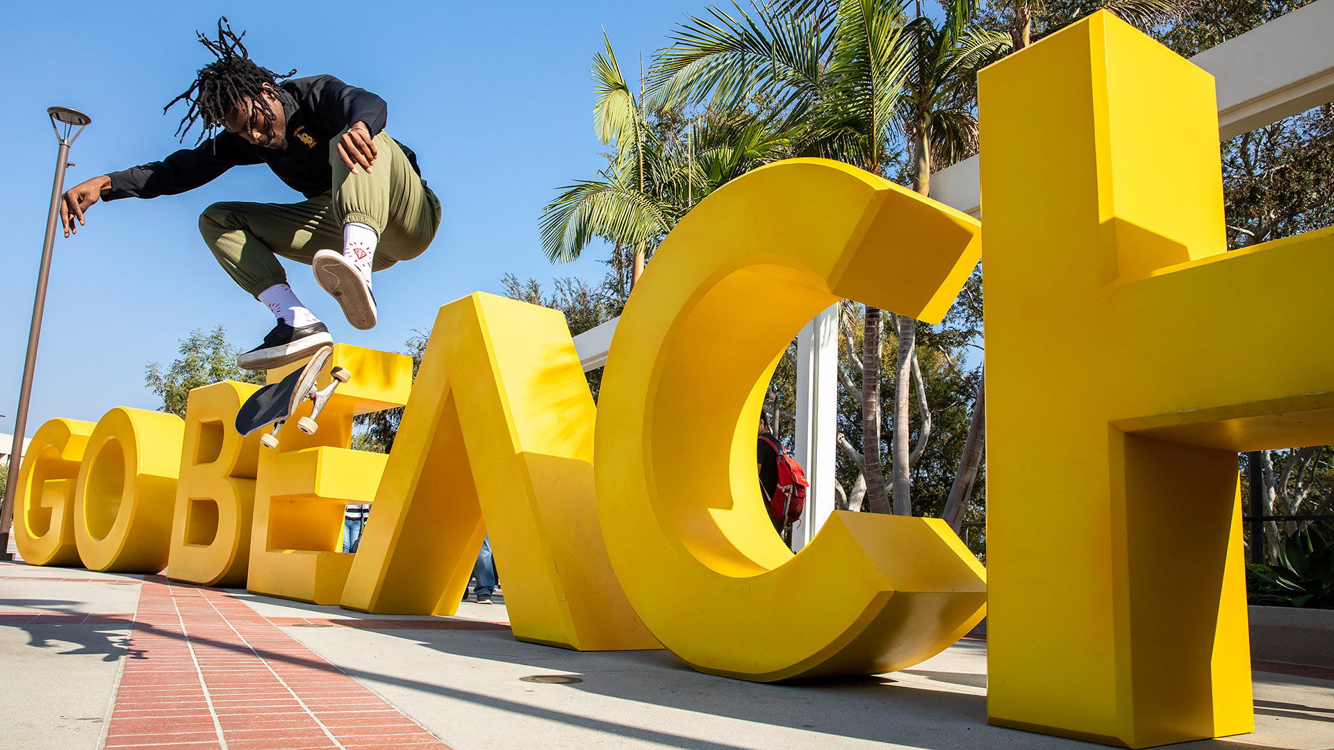 Skateboarder in front of BEACH letters