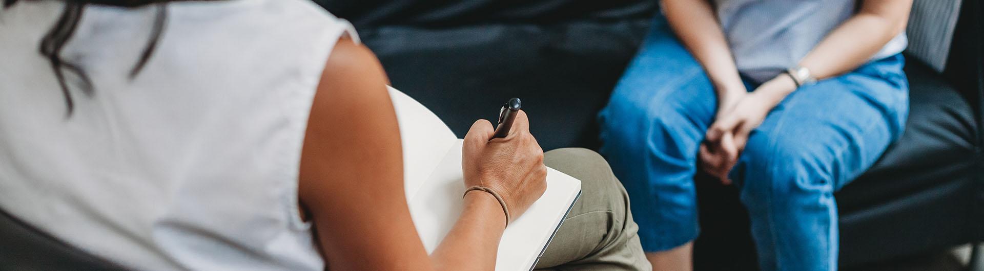 Woman taking notes during a therapy session
