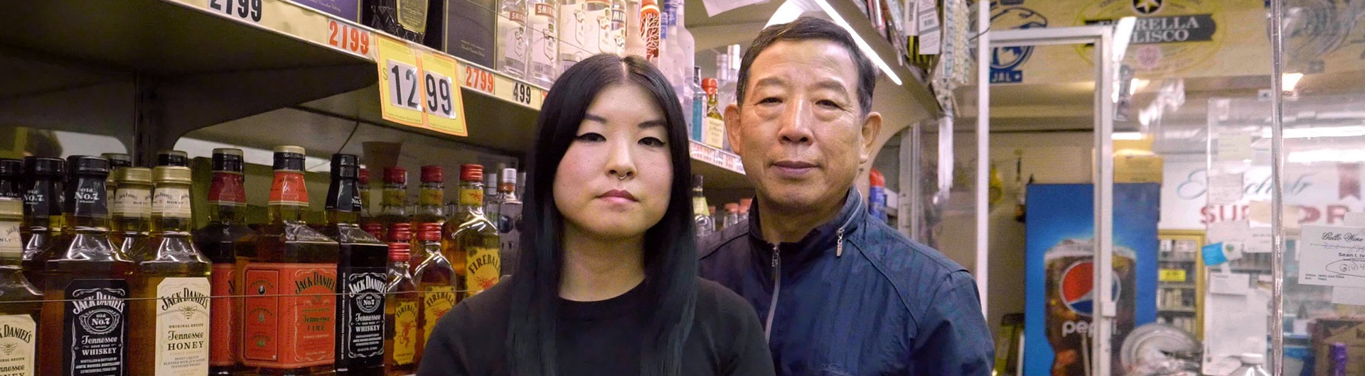 Two people standing in a liquor store by shelfs of alcohol
