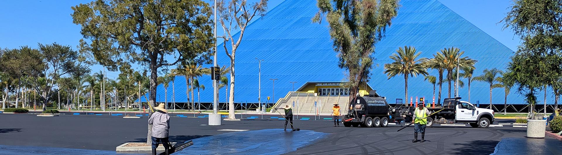 Workers repaving a parking lot in front of Walter Pyramid