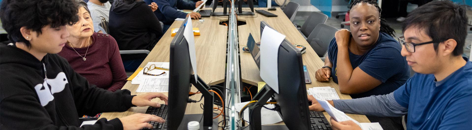 VITA accounting students work at a computer lab, assisting individuals with tax filing. VITA accounting students work at a computer lab, assisting individuals with tax filing.