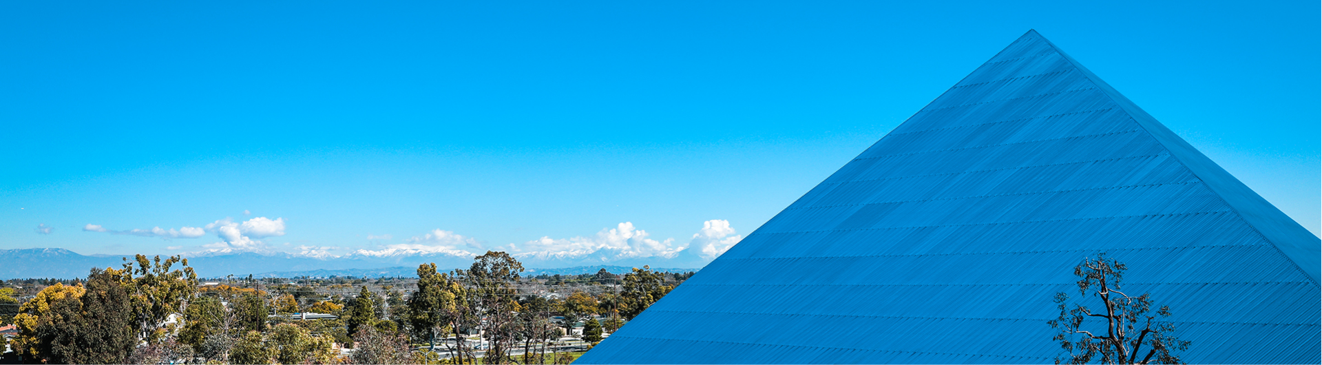 CSU Long Beach blue pyramid with trees and buildings in the distance
