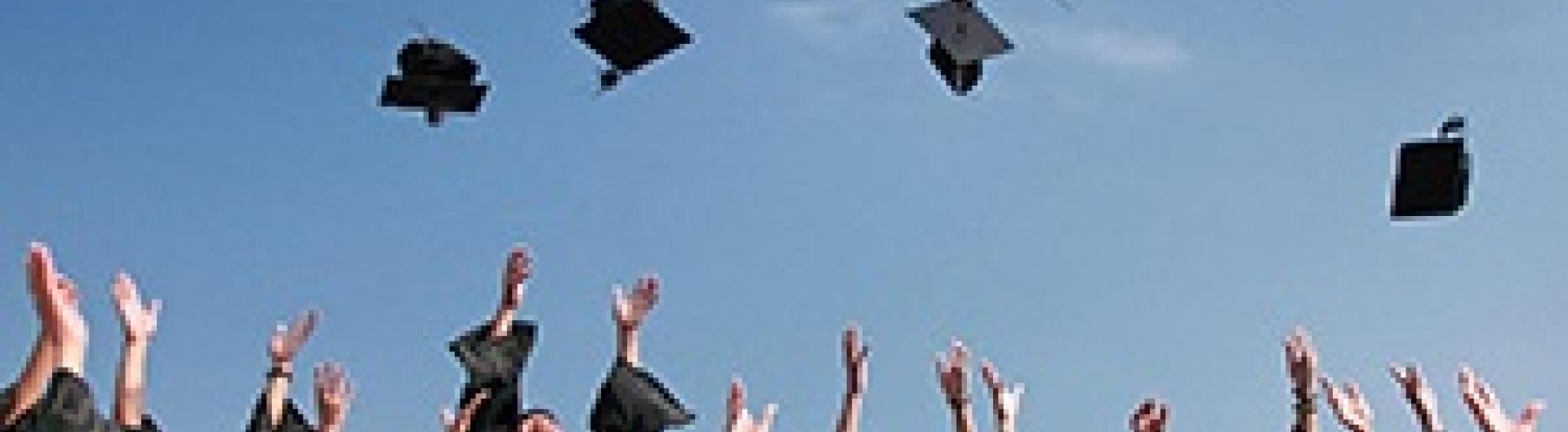 students throwing their graduation caps in the air