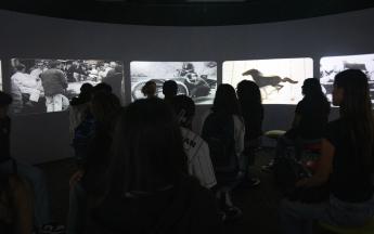 students staring at screen showing black and white clips