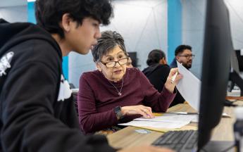 Student in COB LAB helping with a Lady with Tax Service