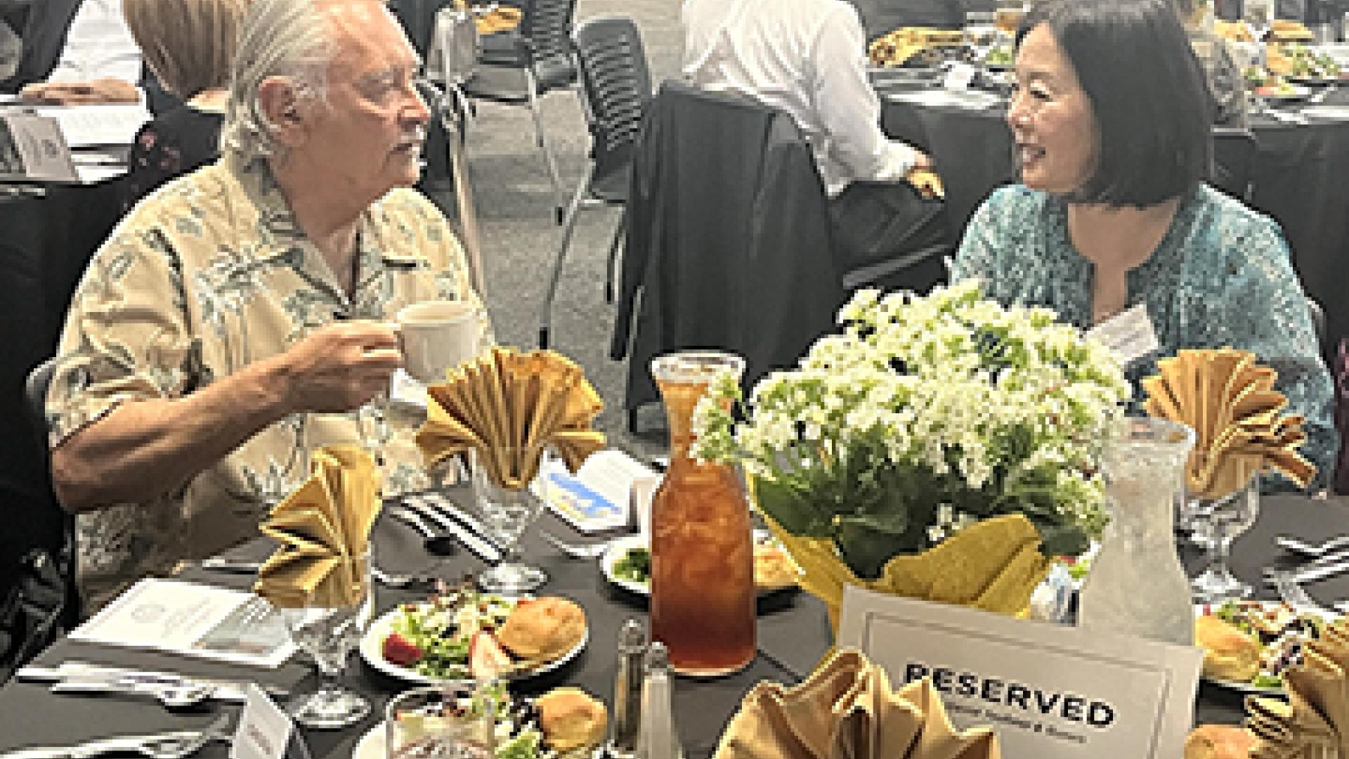 Rob Westerkamp and Shelly Takahashi Sitting at a table