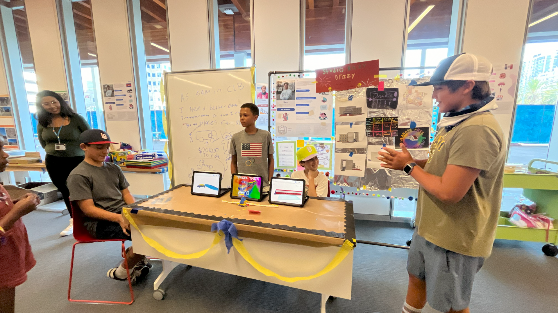 3 students and their mentor presenting their sustainable train SEED Showcase project.