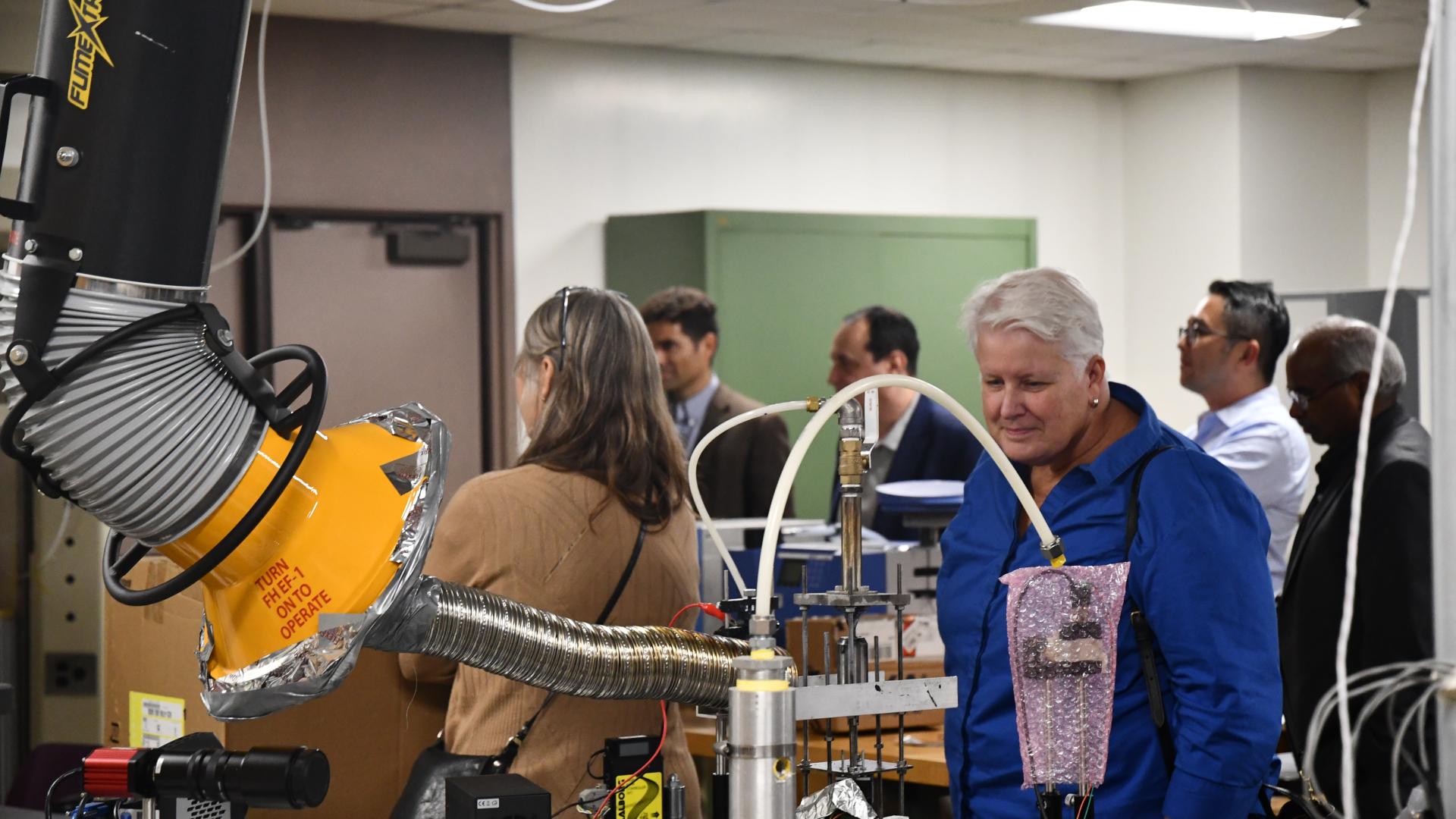 College of Engineering Dean wearing blue blouse looking at state of the art tech in an instructional lab