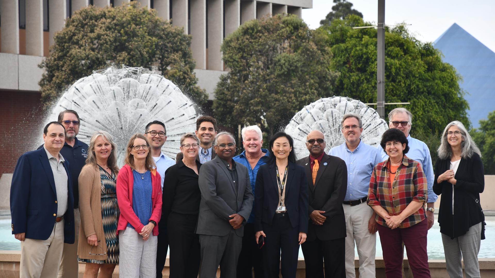 Group of all the college of engineering deans with the Brotman Hall fountain and Walter Pyramid behind them