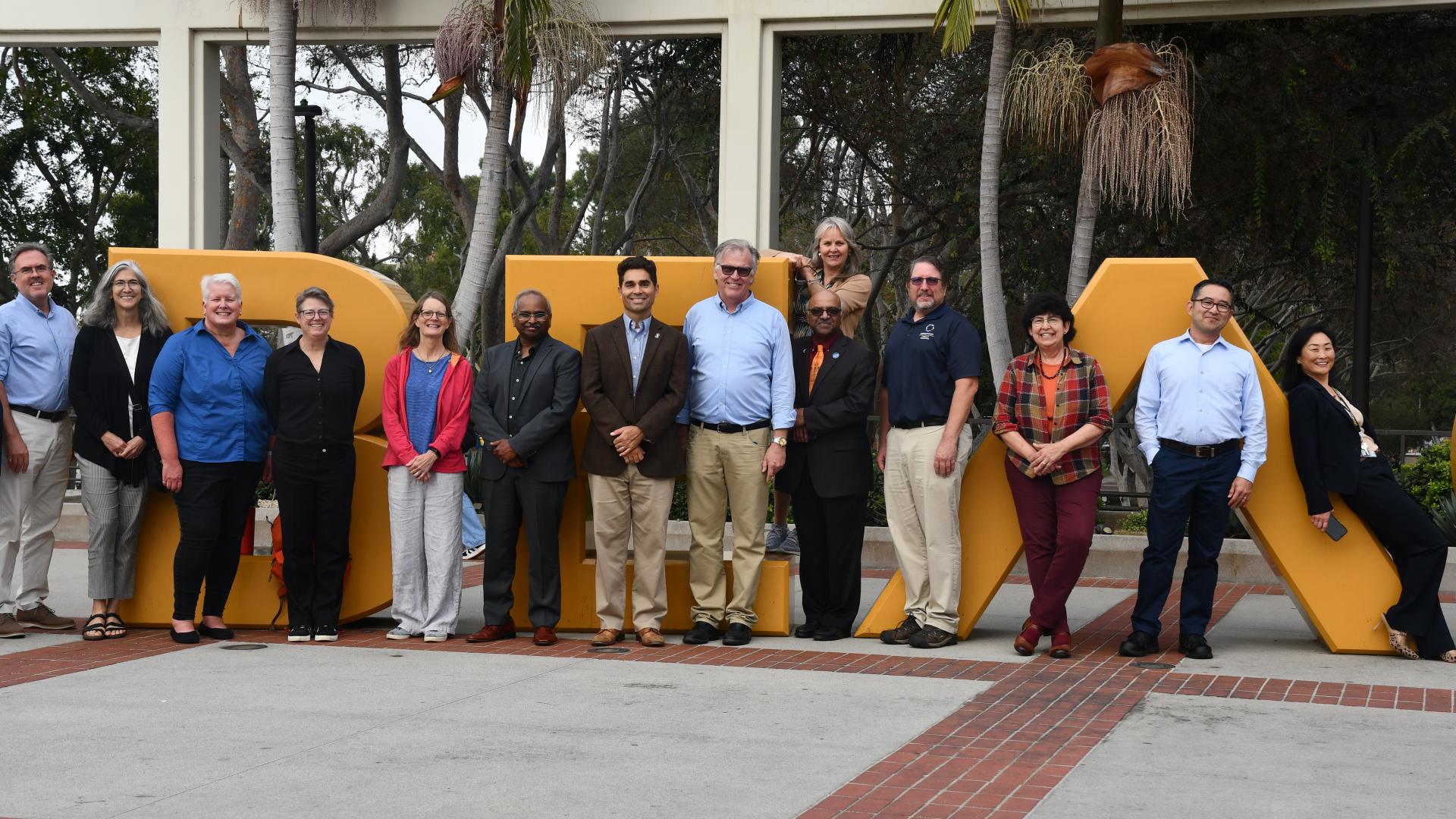 Colleges of Engineering Deans posed for a photo by the GO BEACH letter sign