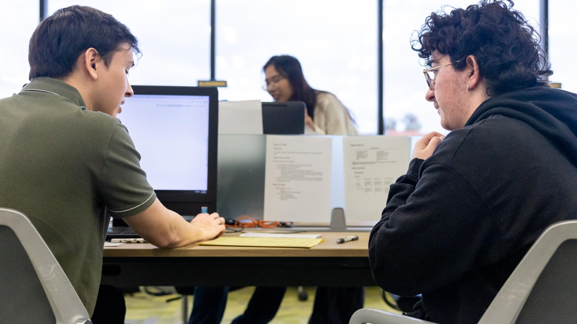 Student in COB LAB helping with a Gentleman with Tax Service