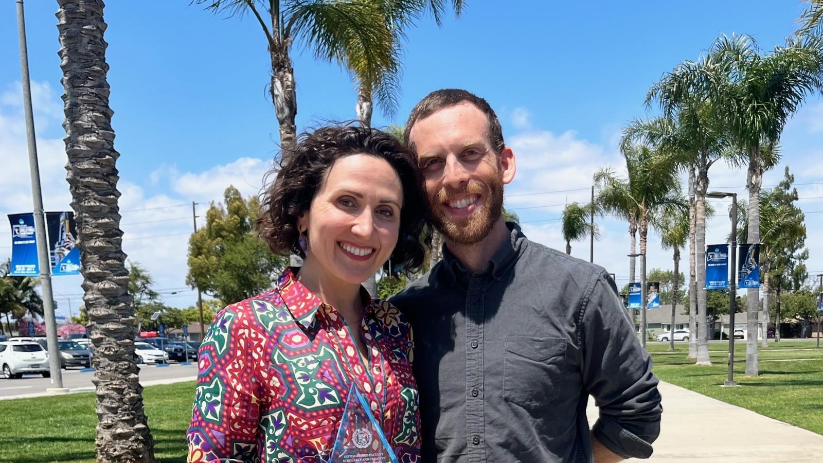 Associate Professor Andrea Caban stands with Department Chair Ezra Lebank with her 2024 Distinguished Faculty Scholarly and Creative Achievement Award