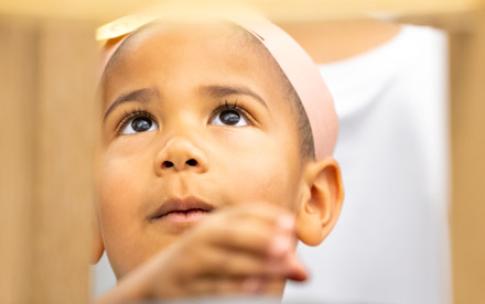 A young girl peers up at an experiment at the Science Learning Center.