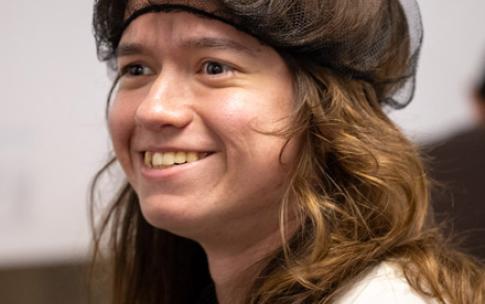 A Summer LIFE student with long hair wears a hairnet and smiles.