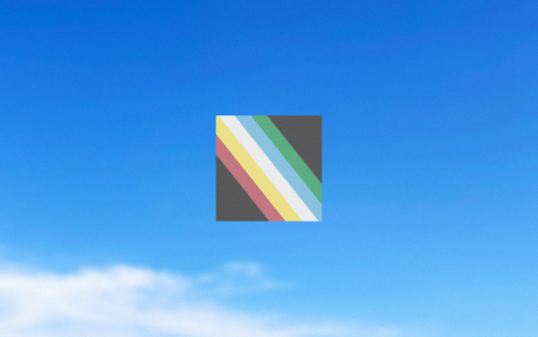 Disability Pride Flag against a blue sky. Please read caption.