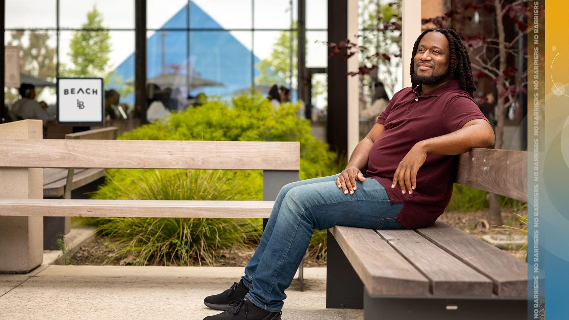 Joshua James, a recipient of the Black Alumni Scholarship, seated at a bench