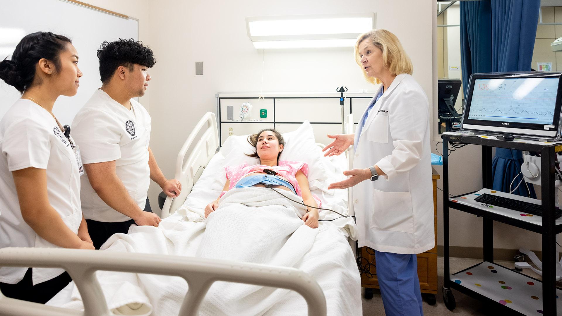 Students in the CSULB Nursing School conduct a mock examination of a patient.