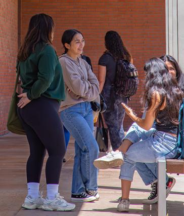 CSULB students have a conversation in a hallway on campus.