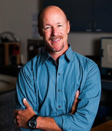 Portrait of Chris Lowe, Shark Lab director at CSLUB, in a blue shirt with his arms crossed