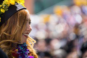 Side profile of a woman smiling and wearing a graduation cap.