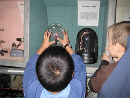 kids touching a plasma globe