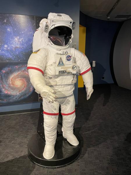 A space suit worn in space on display in a museum.