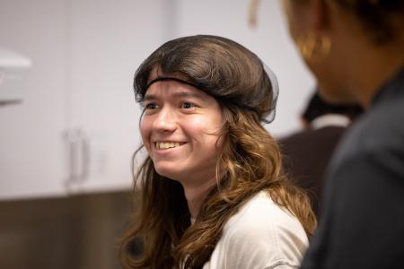 A Summer LIFE student with long hair wears a hairnet and smiles.