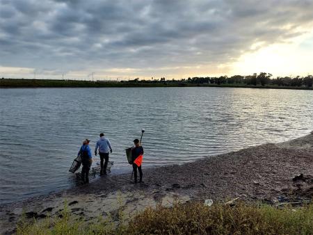 student researchers standing at the shore