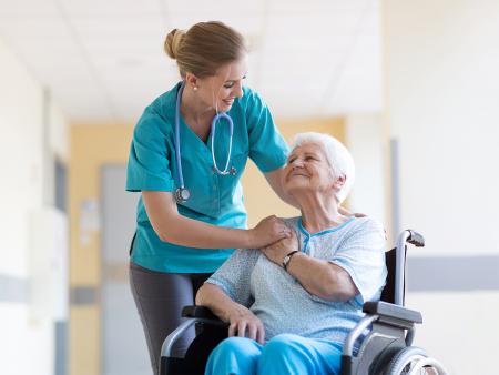 nurse comforting patient in wheelchair