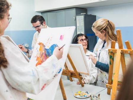 occupational therapist helping patient with paint brush strokes