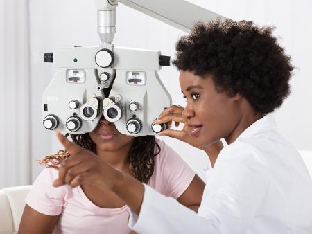 optometrist performing eye examination on patient