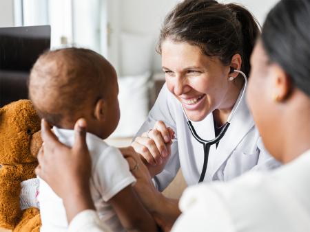 physician smiling at baby patient