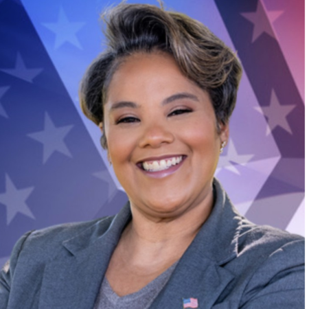 Bridget Lewis is seen wearing American flag pin, standing against a patriotic star-patterned background.