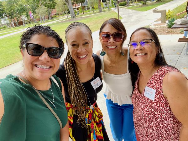 Nat Hansuvadha poses for picture with three master's degree students.