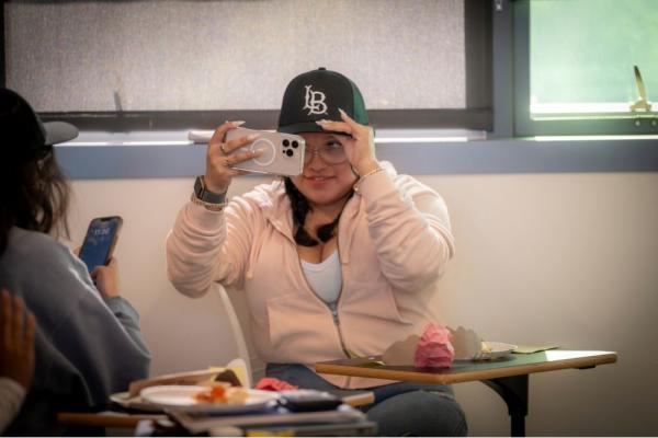 Student taking a selfie with Beach XP hat. 